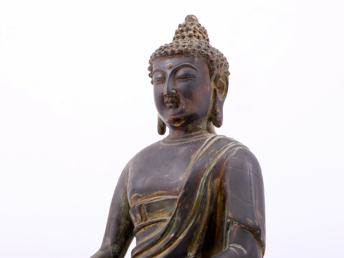 A serene gilt bronze statue of Gautama Buddha