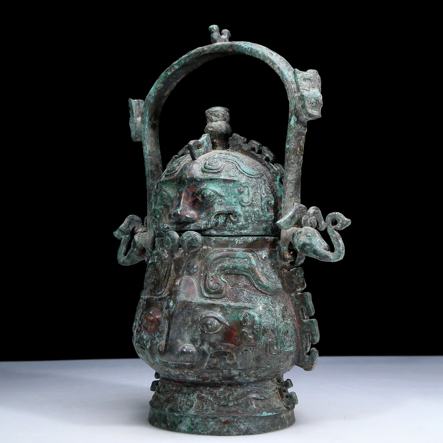 An Archaic Bronze 'Animal Mask' Pot With Inscriptions And An Overhead Handle