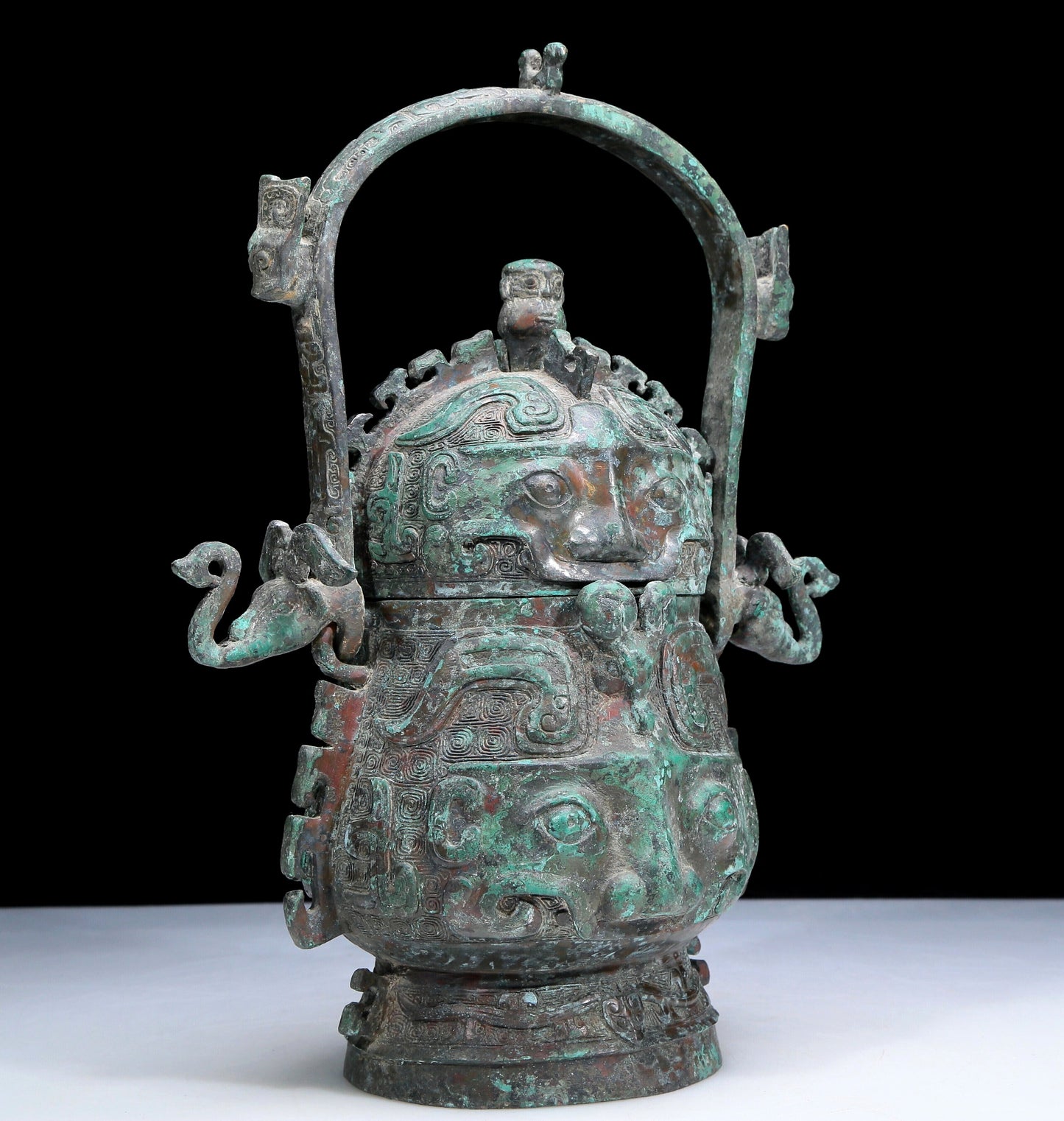 An Archaic Bronze 'Animal Mask' Pot With Inscriptions And An Overhead Handle