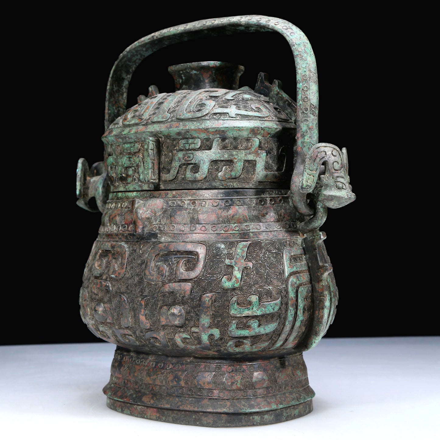 An Archaic Bronze 'Animal Mask' Pot With Inscriptions And An Overhead Handle
