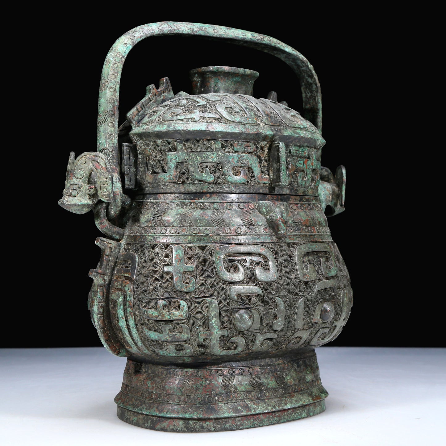 An Archaic Bronze 'Animal Mask' Pot With Inscriptions And An Overhead Handle