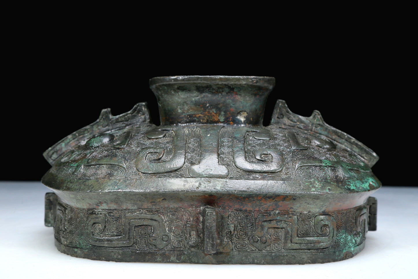 An Archaic Bronze 'Animal Mask' Pot With Inscriptions And An Overhead Handle