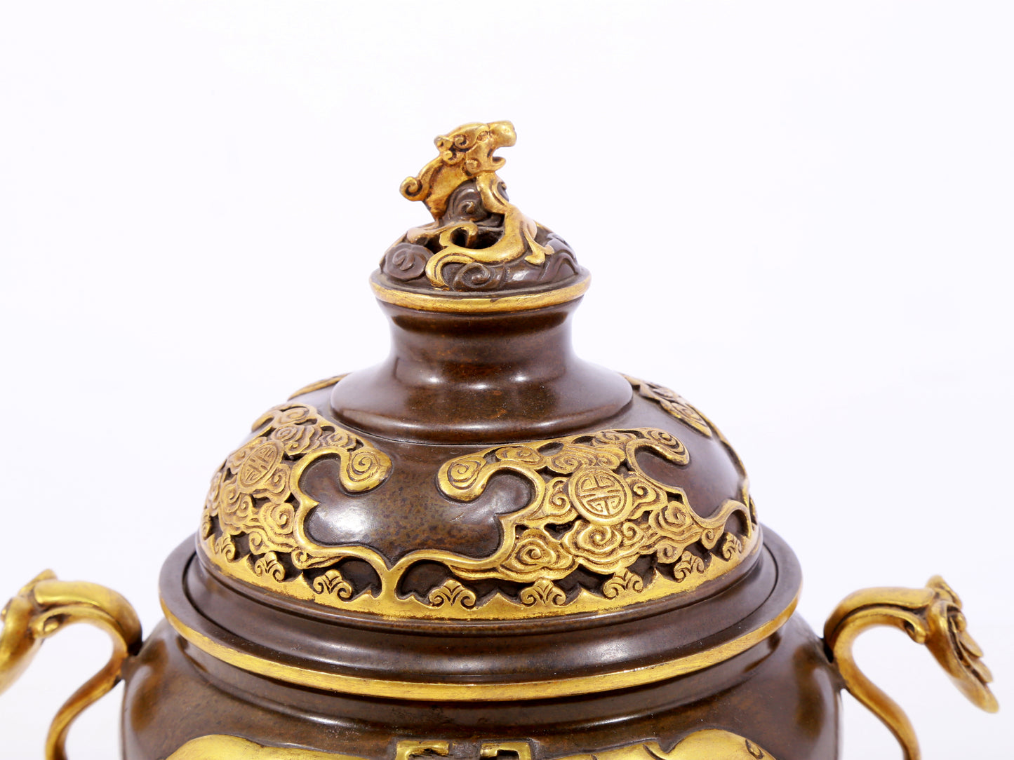 An exquisite gilt copper double-eared and tripod stove with 'auspicious clouds and chilong' patterns and a lid.