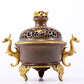 An exquisite gilt copper double-eared and tripod stove with 'auspicious clouds and chilong' patterns and a lid.