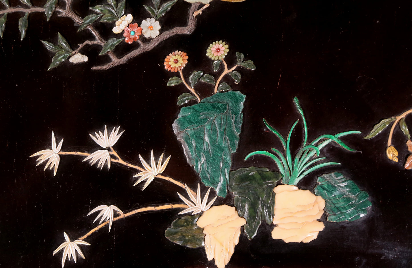 An exquisite lacquered huanghuali wood hanging screen with flower and bird patterns inlaid with gemstones