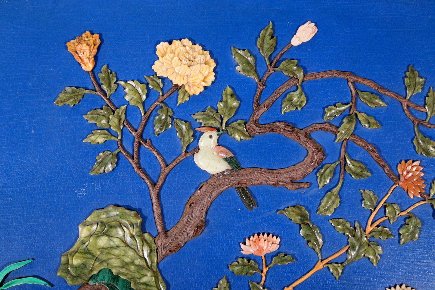 An exquisite lacquered huanghuali wood hanging screen with flower and bird patterns inlaid with gemstones