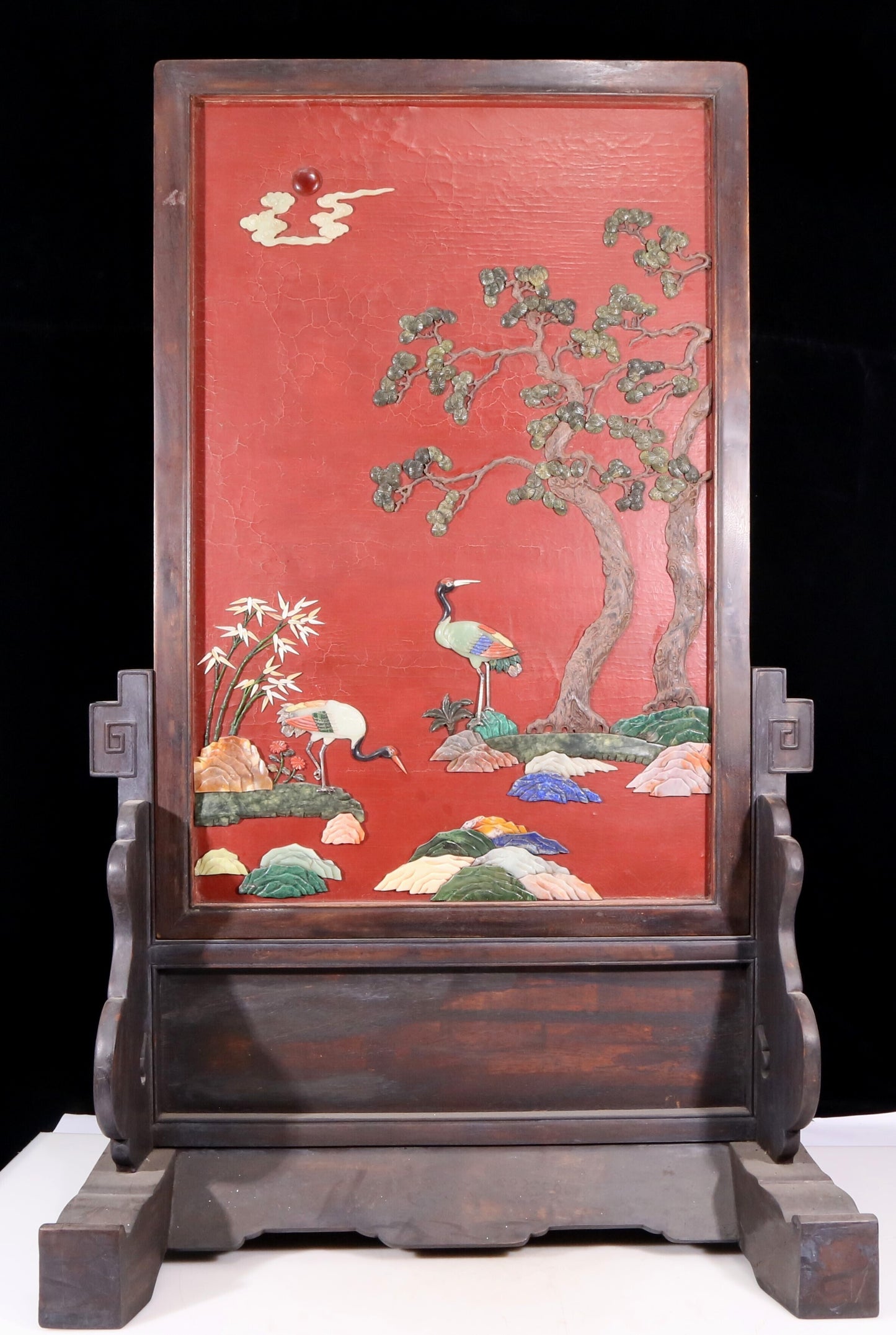 An exquisite zitanwood lacquered table screen with a pine and crane pattern inlaid with gemstones