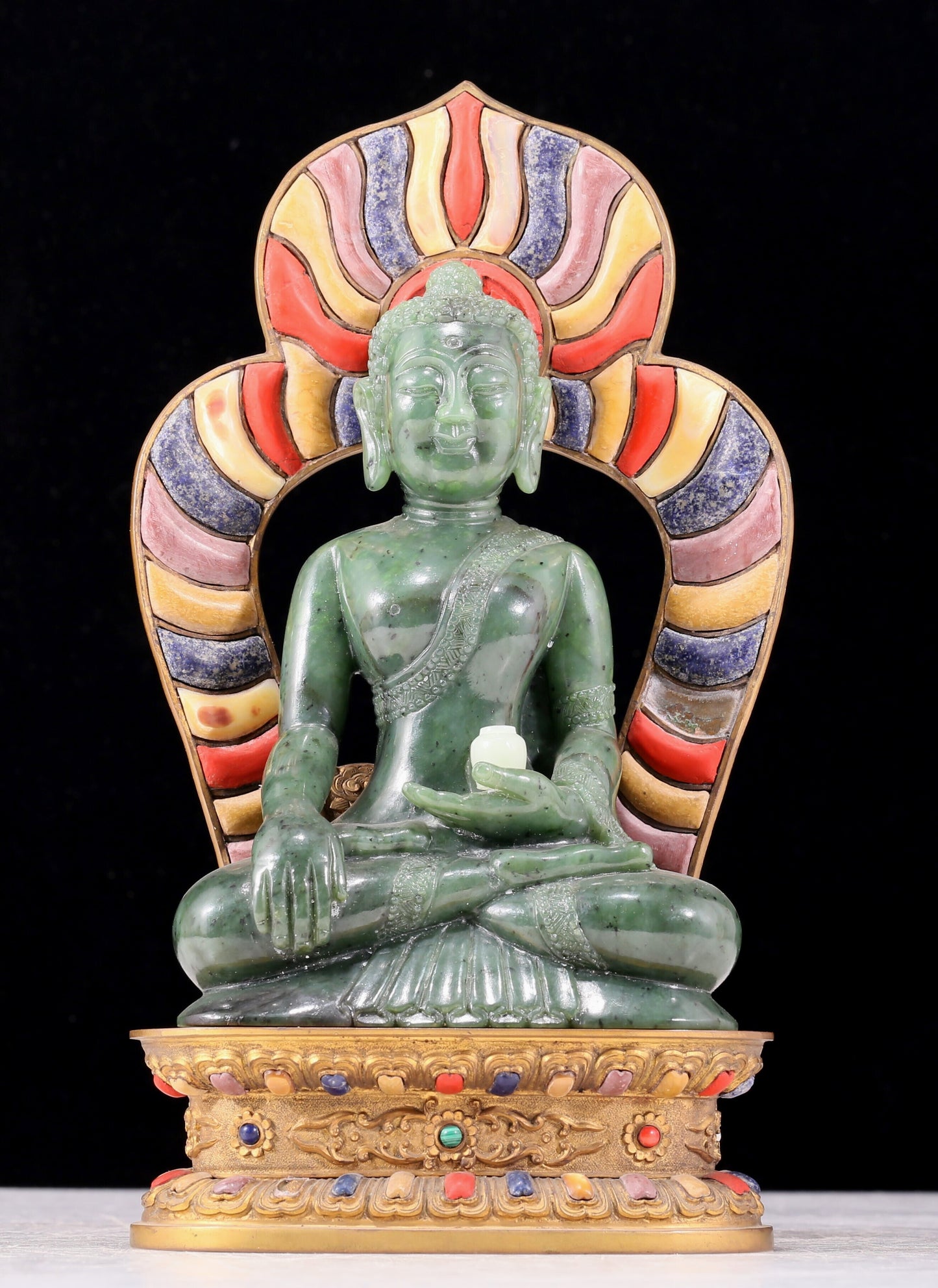 A solemn gilt bronze and gem-set jasper statue of Gautama Buddha