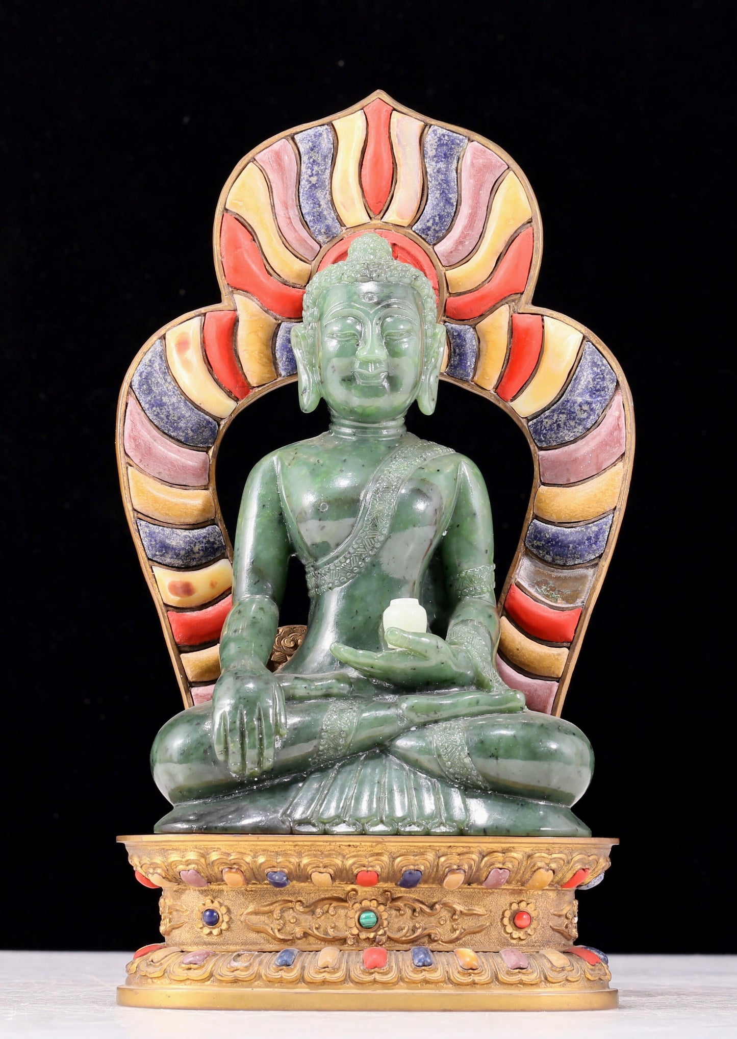 A solemn gilt bronze and gem-set jasper statue of Gautama Buddha