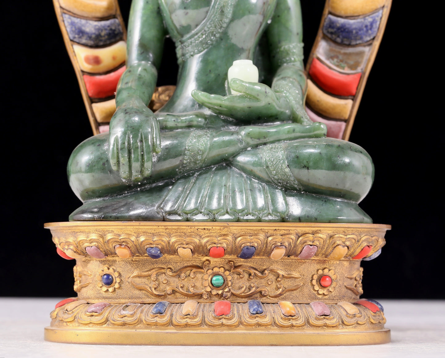 A solemn gilt bronze and gem-set jasper statue of Gautama Buddha