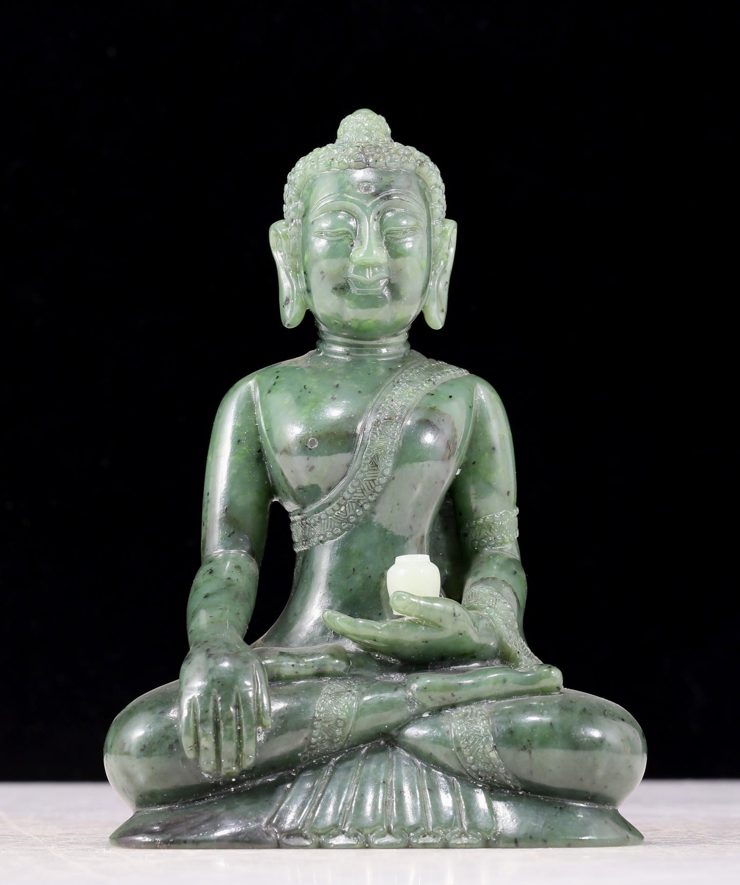 A solemn gilt bronze and gem-set jasper statue of Gautama Buddha