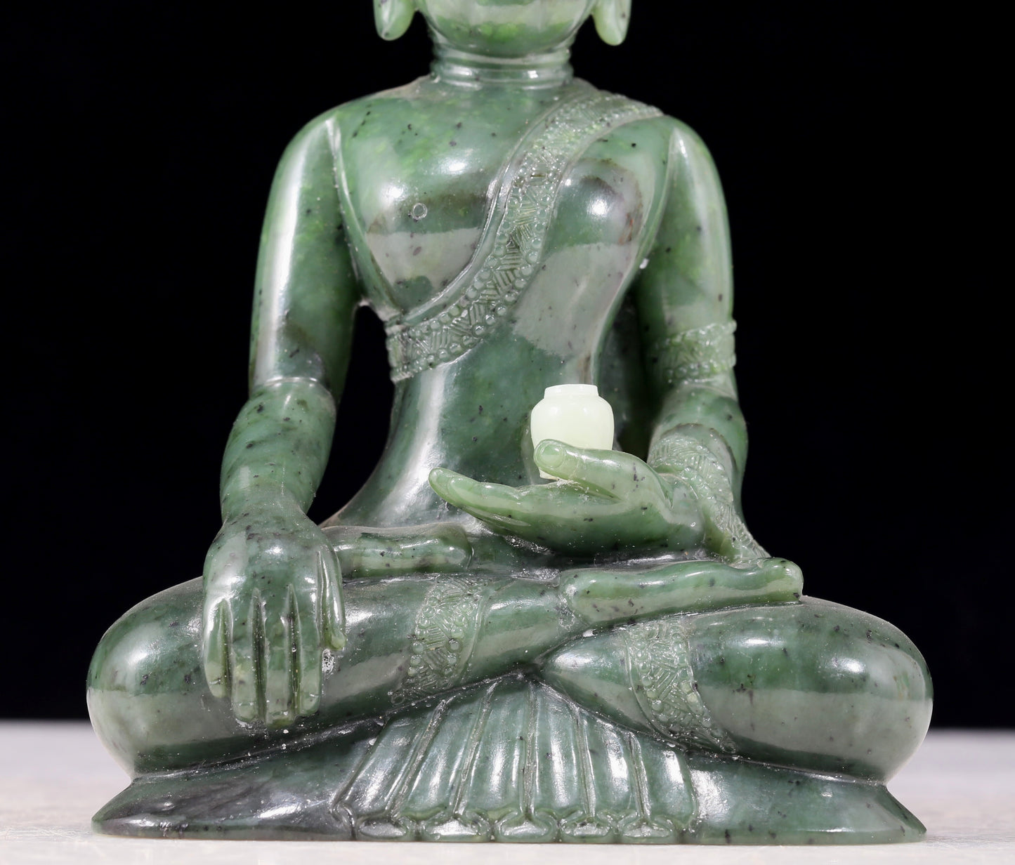 A solemn gilt bronze and gem-set jasper statue of Gautama Buddha