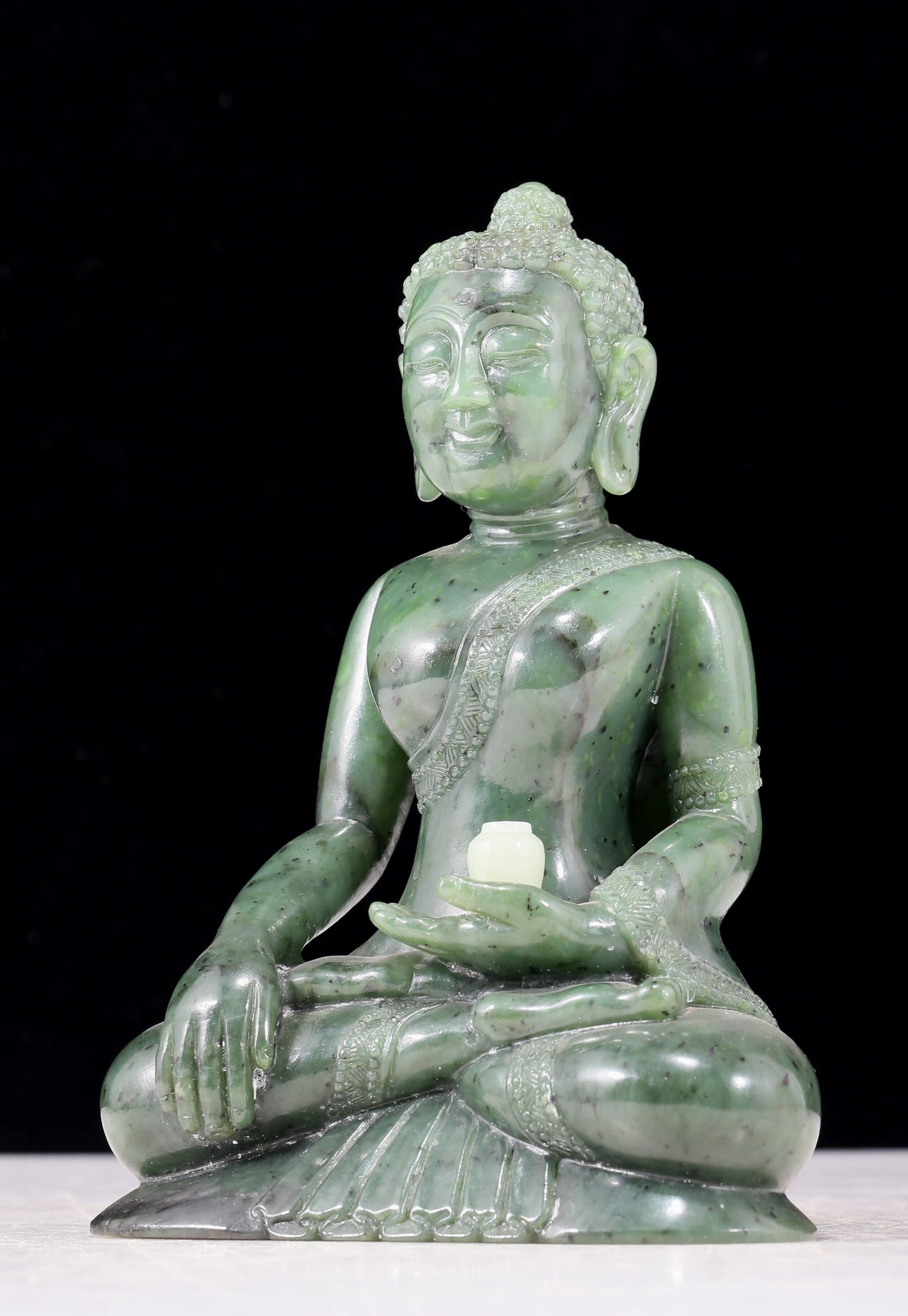 A solemn gilt bronze and gem-set jasper statue of Gautama Buddha