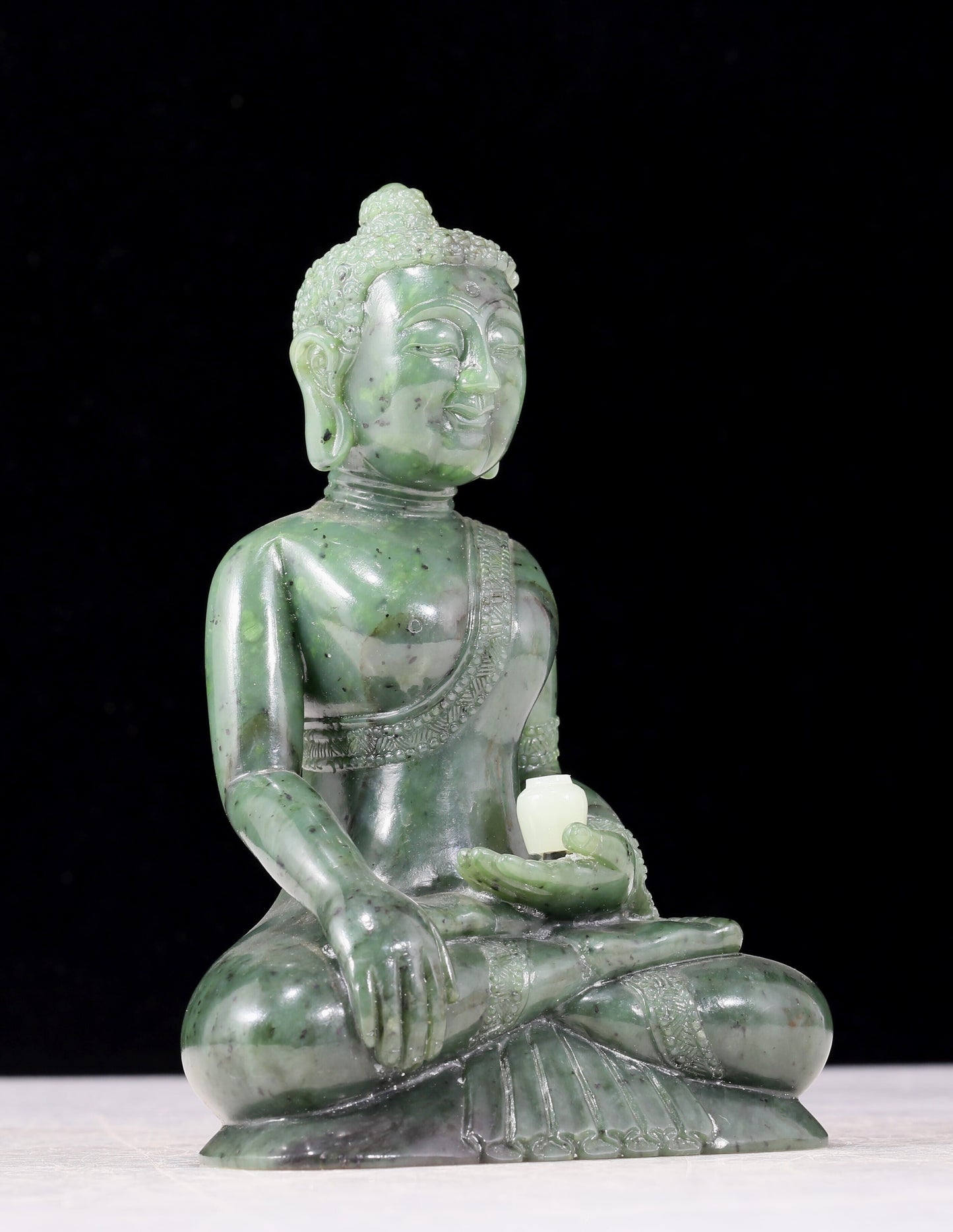 A solemn gilt bronze and gem-set jasper statue of Gautama Buddha