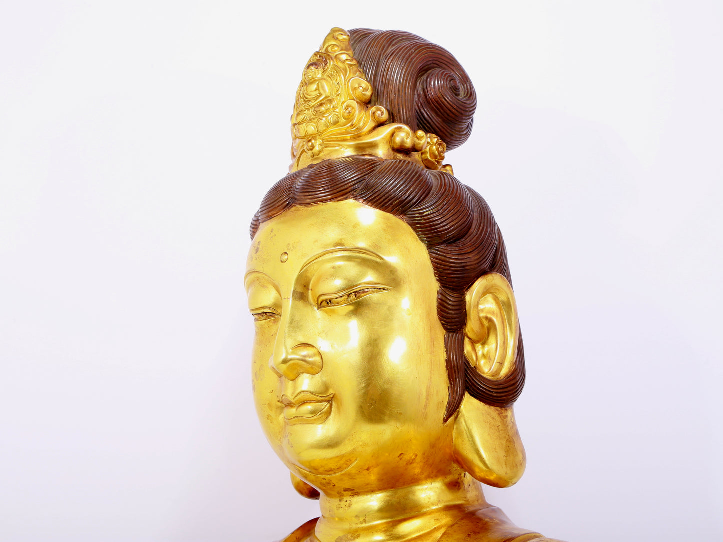 A solemn gilt bronze statue of Guanyin