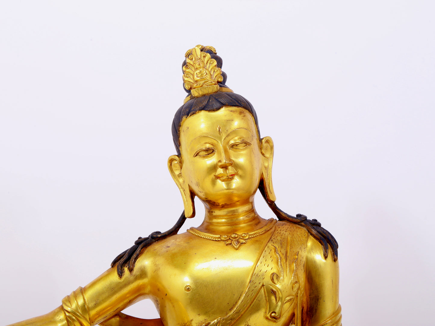 A solemn gilt bronze statue of Guanyin