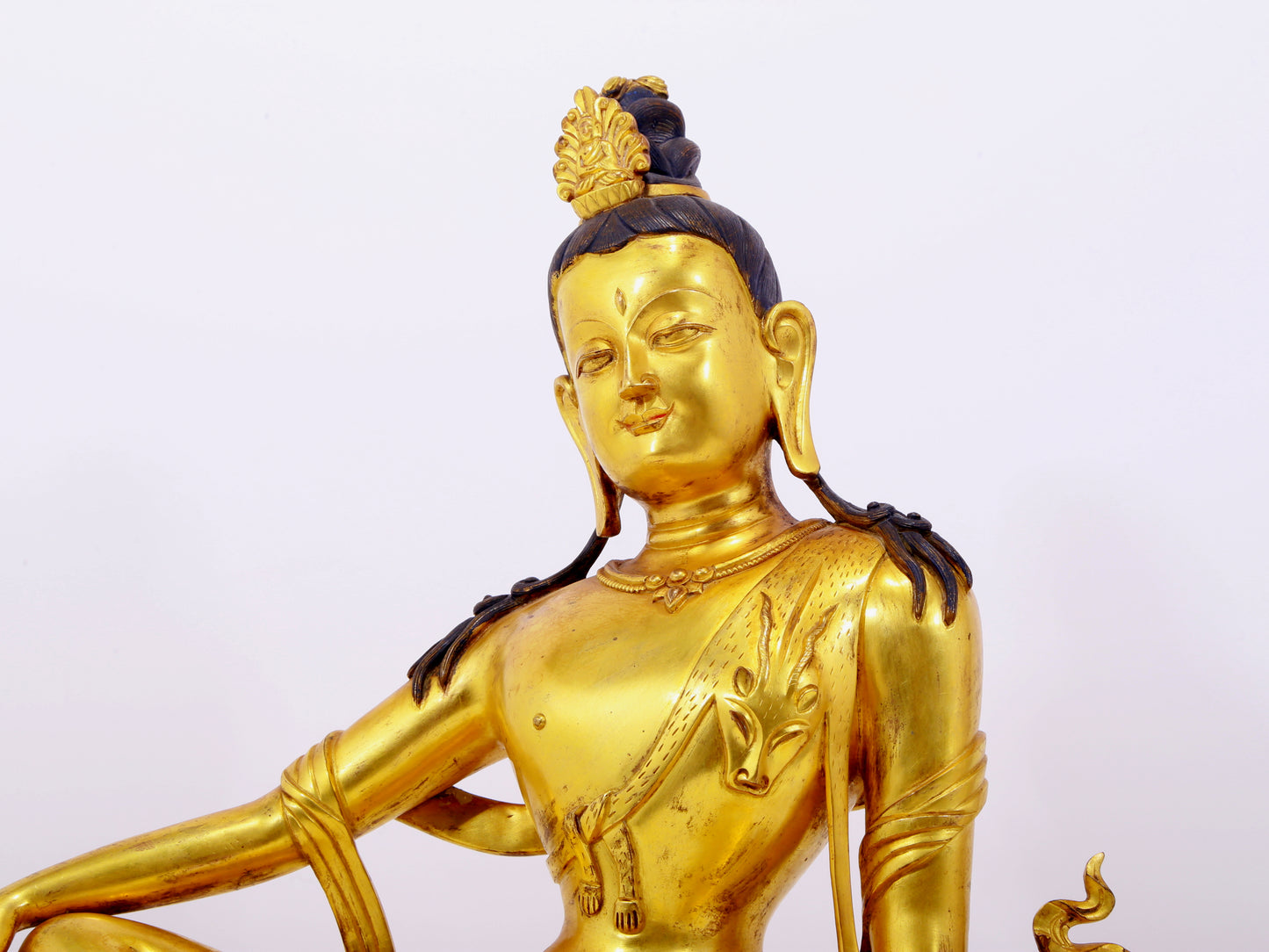 A solemn gilt bronze statue of Guanyin