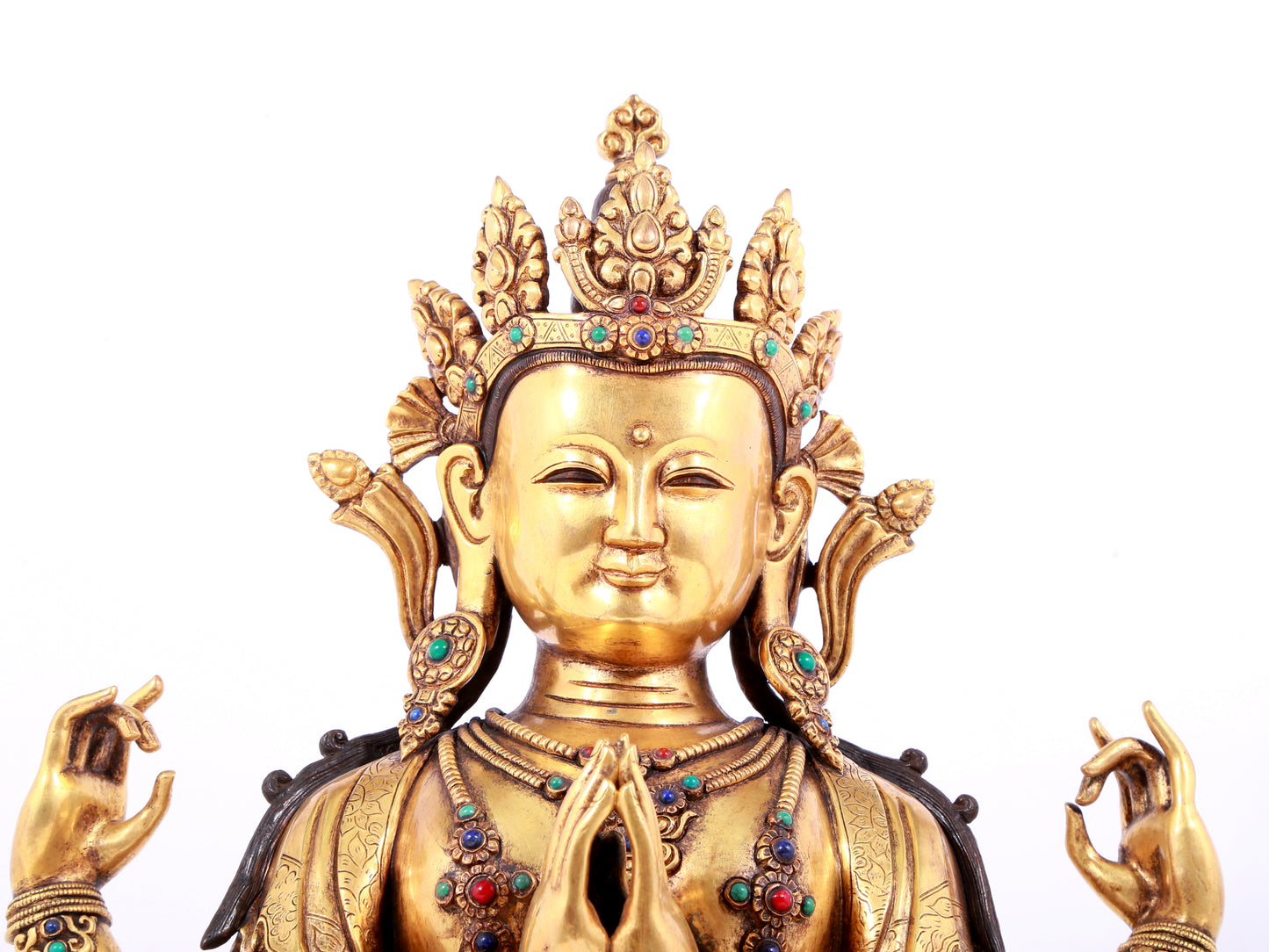 A solemn gilt bronze statue of Guanyin with four arms inlaid gems