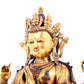 A solemn gilt bronze statue of Guanyin with four arms inlaid gems