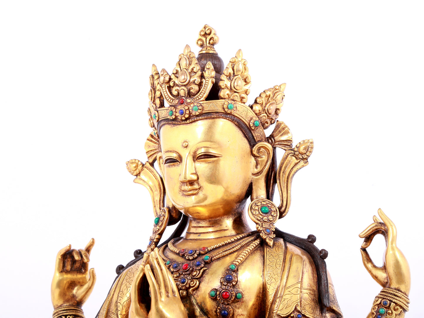 A solemn gilt bronze statue of Guanyin with four arms inlaid gems