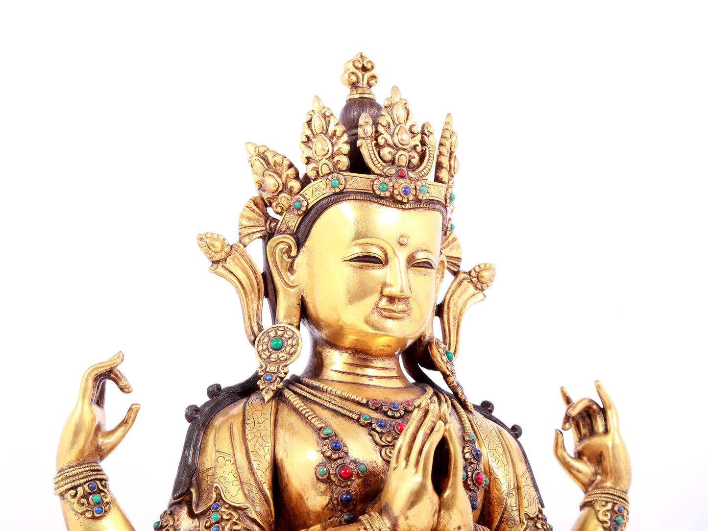 A solemn gilt bronze statue of Guanyin with four arms inlaid gems