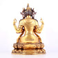 A solemn gilt bronze statue of Guanyin with four arms inlaid gems