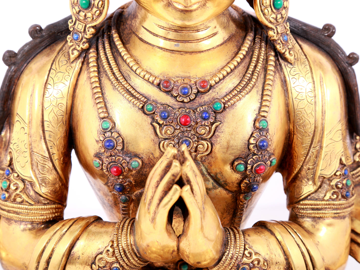 A solemn gilt bronze statue of Guanyin with four arms inlaid gems