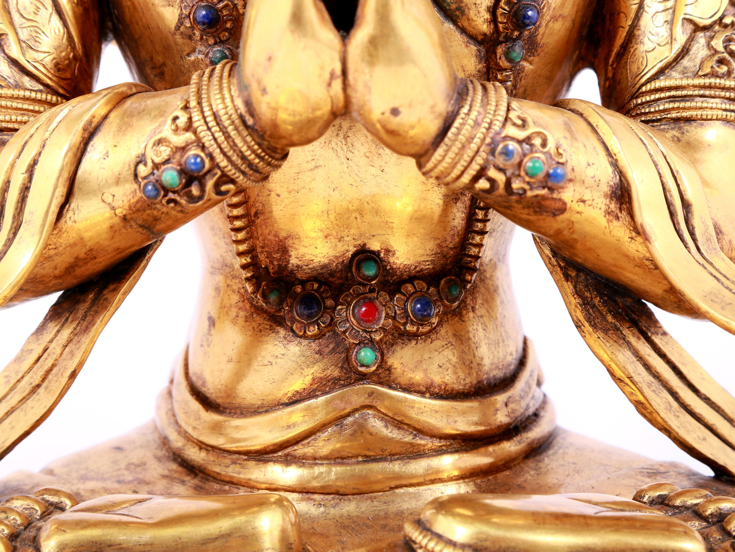 A solemn gilt bronze statue of Guanyin with four arms inlaid gems