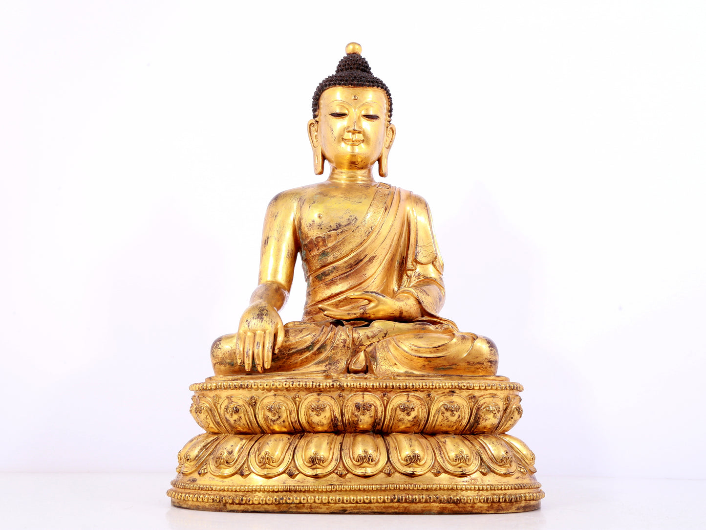 A solemn gilt bronze statue of Sakyamuni