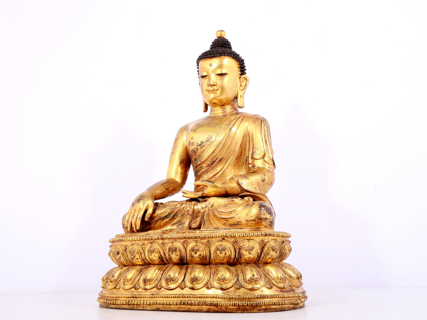 A solemn gilt bronze statue of Sakyamuni