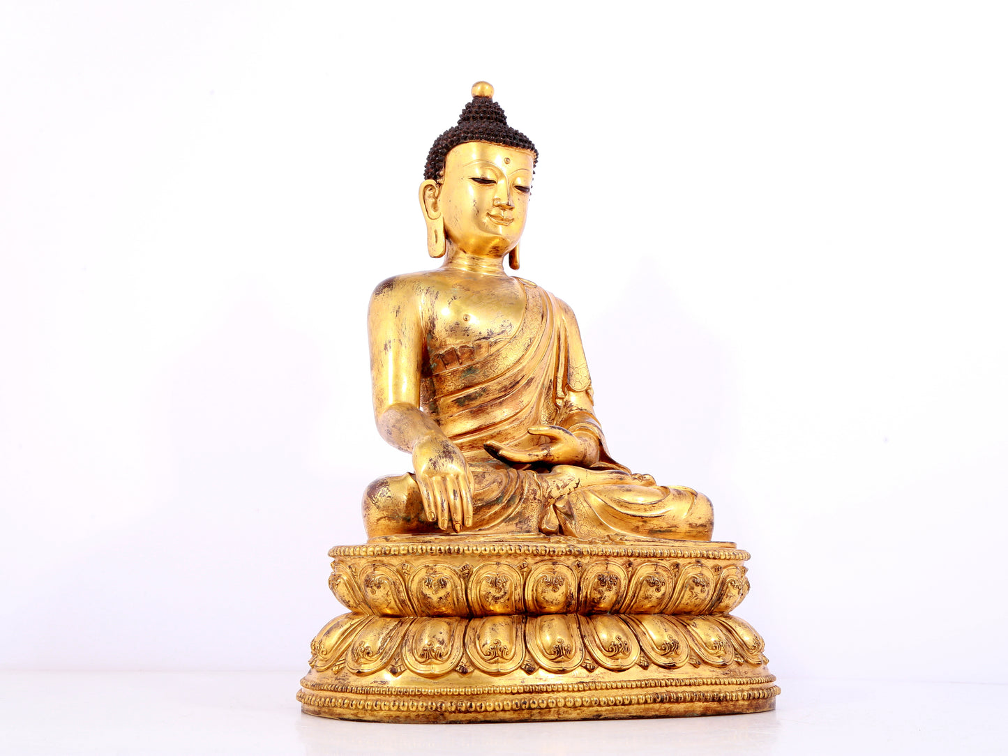 A solemn gilt bronze statue of Sakyamuni