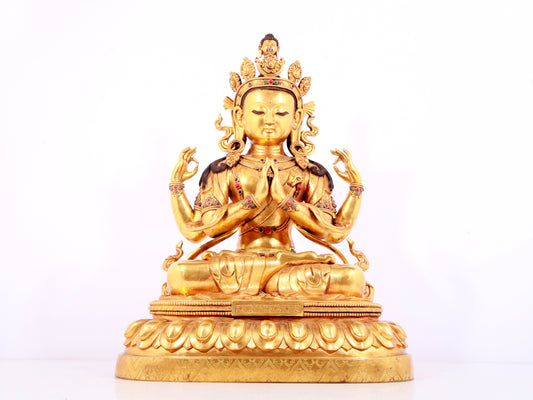 A solemn gilt bronze statue of Guanyin with four arms inlaid gems