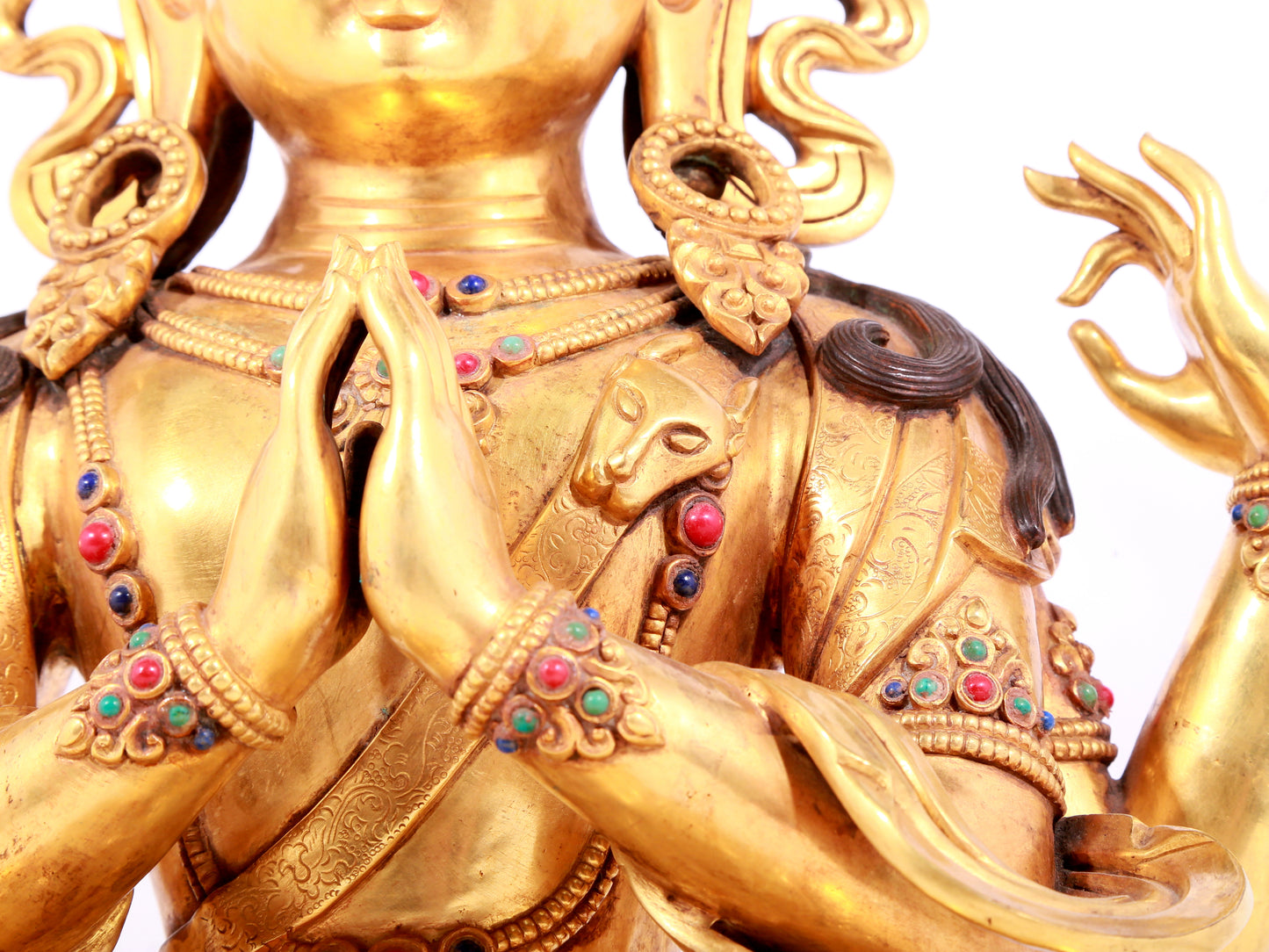 A solemn gilt bronze statue of Guanyin with four arms inlaid gems