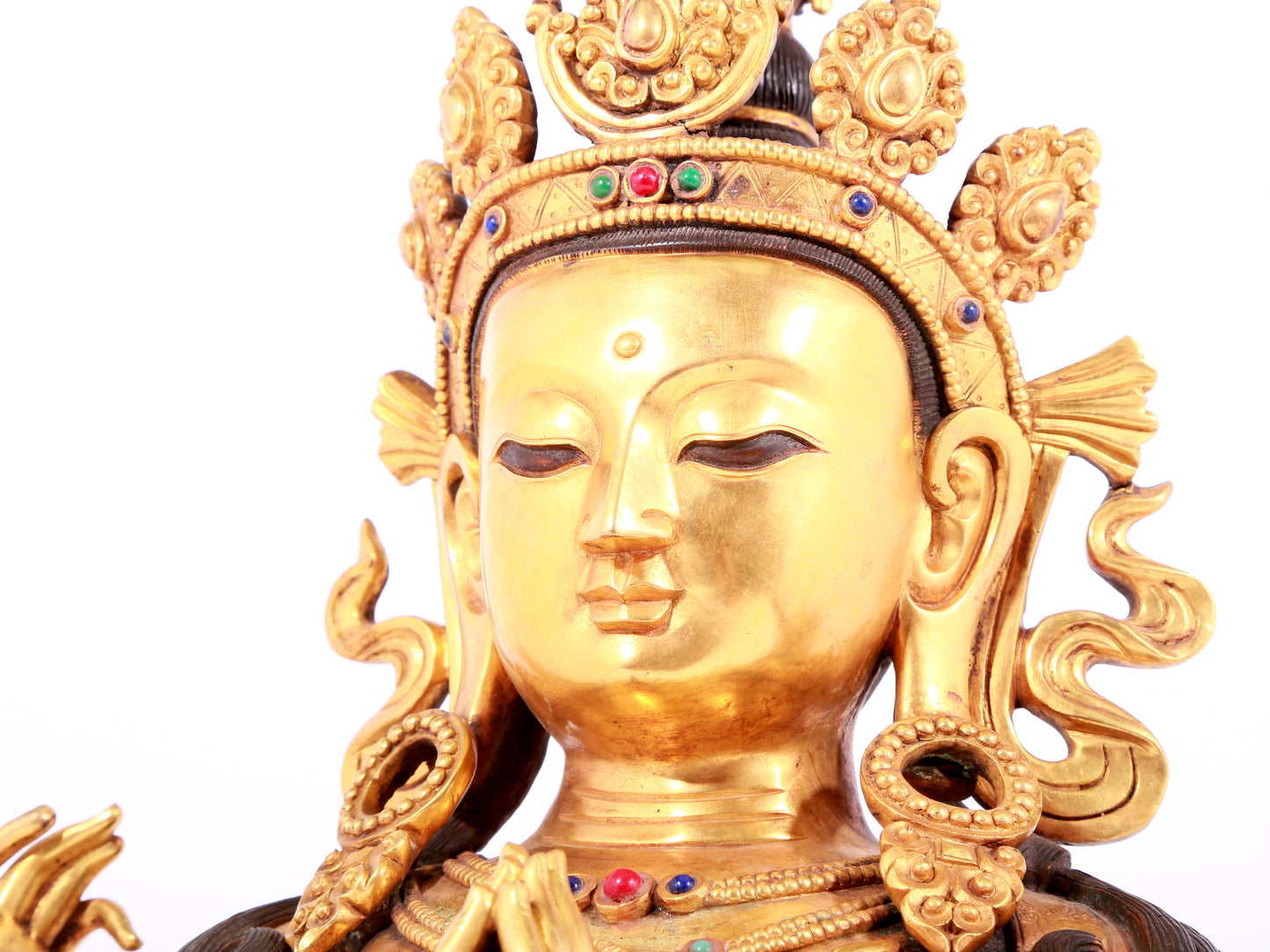 A solemn gilt bronze statue of Guanyin with four arms inlaid gems