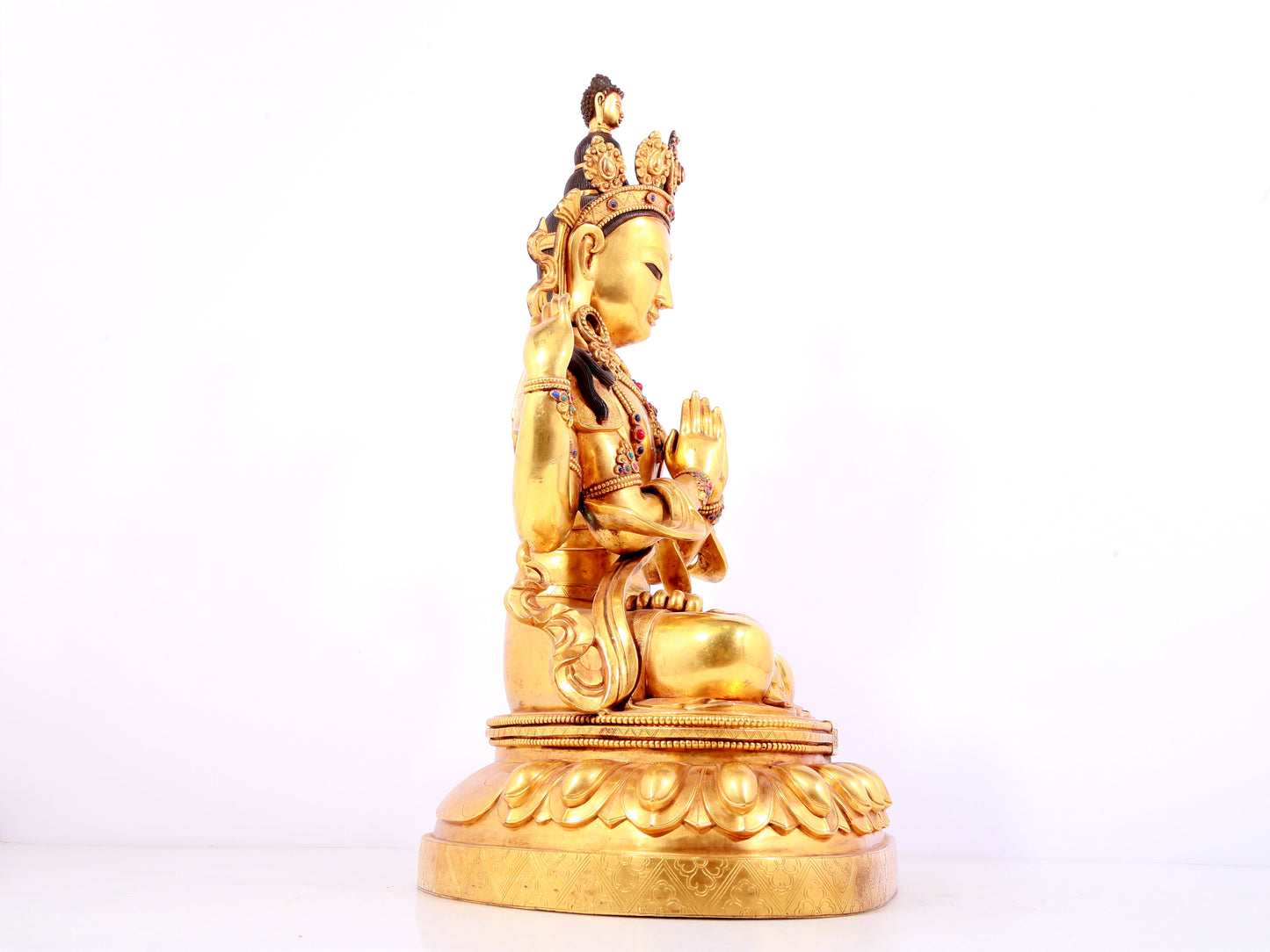 A solemn gilt bronze statue of Guanyin with four arms inlaid gems