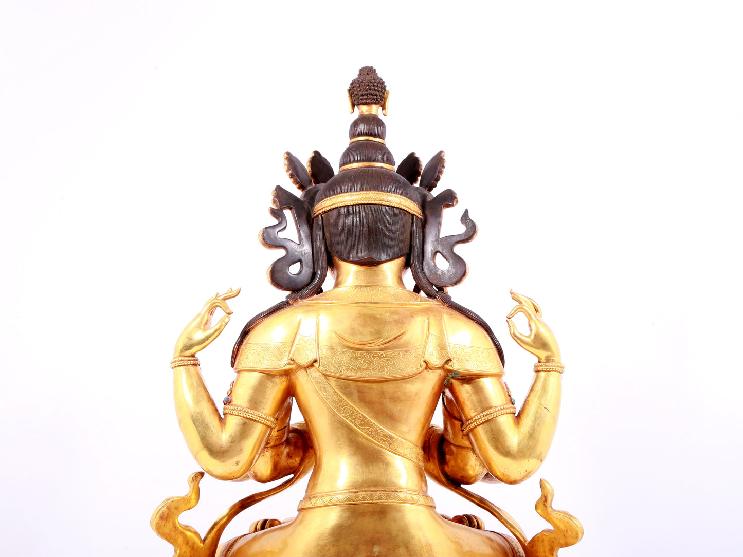 A solemn gilt bronze statue of Guanyin with four arms inlaid gems