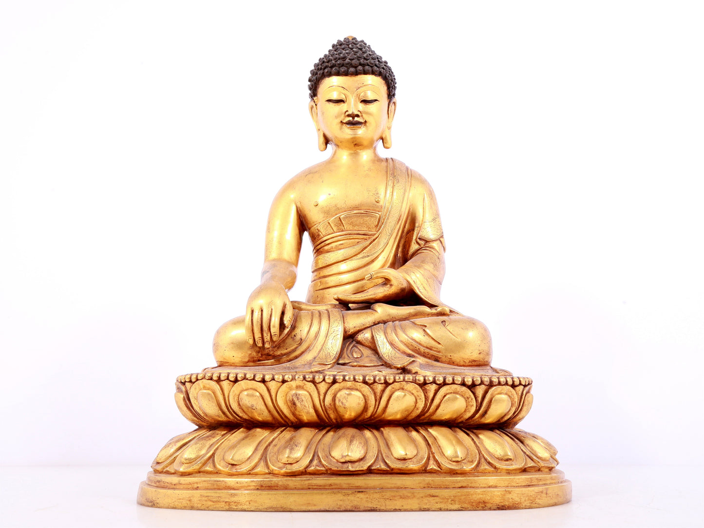 A solemn gilt bronze statue of Sakyamuni