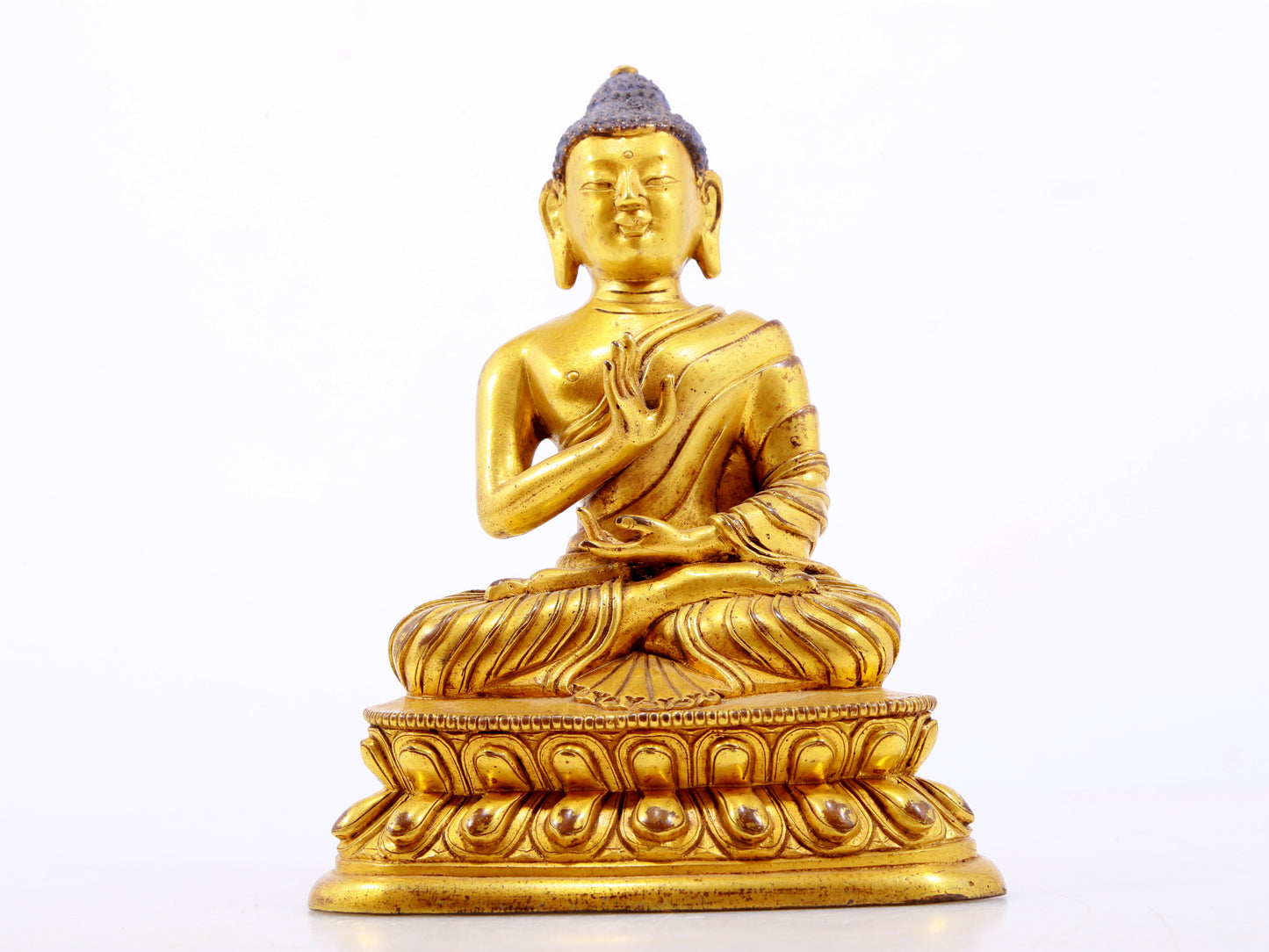 A serene gilt bronze statue of Gautama Buddha