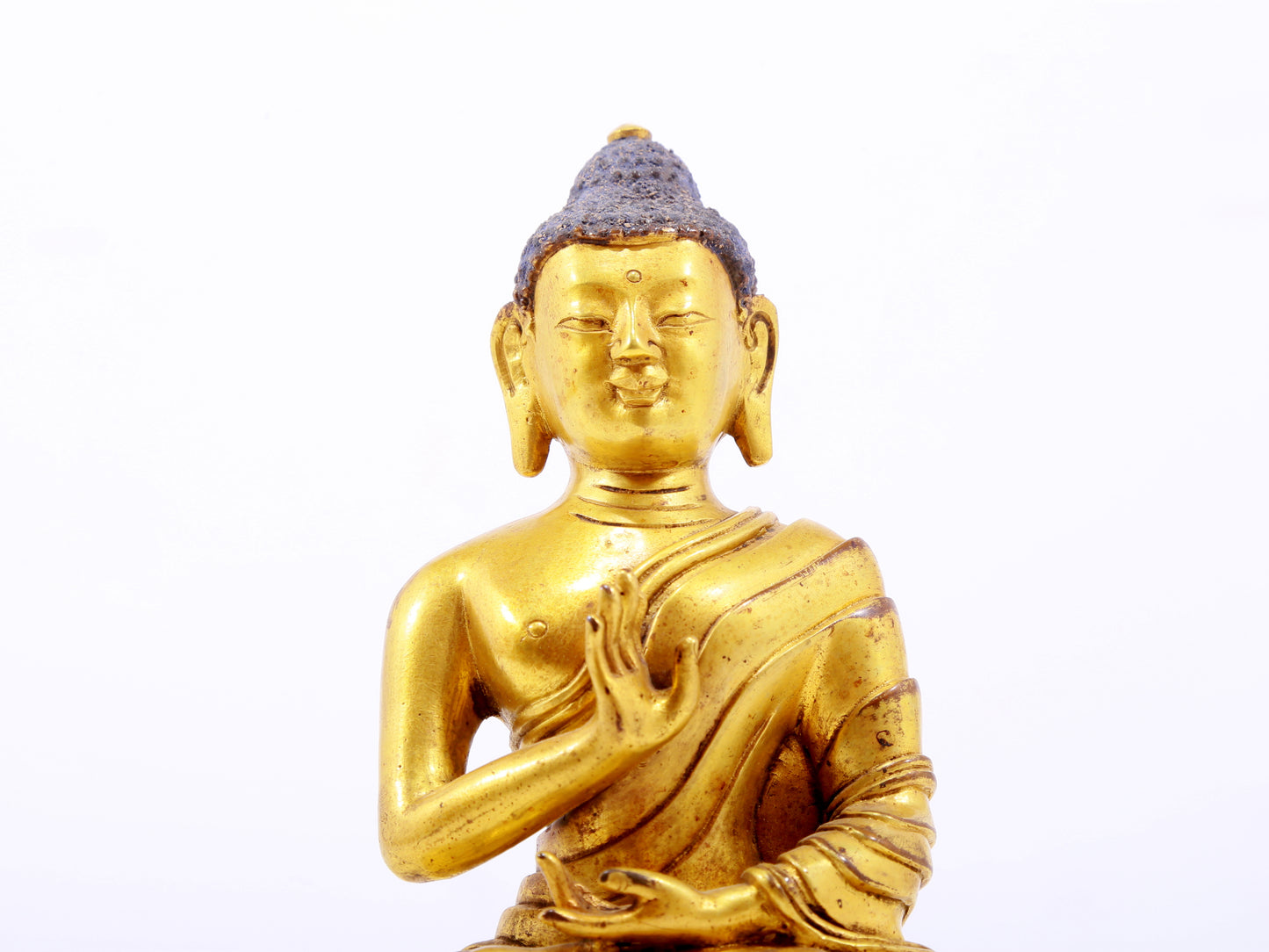 A serene gilt bronze statue of Gautama Buddha