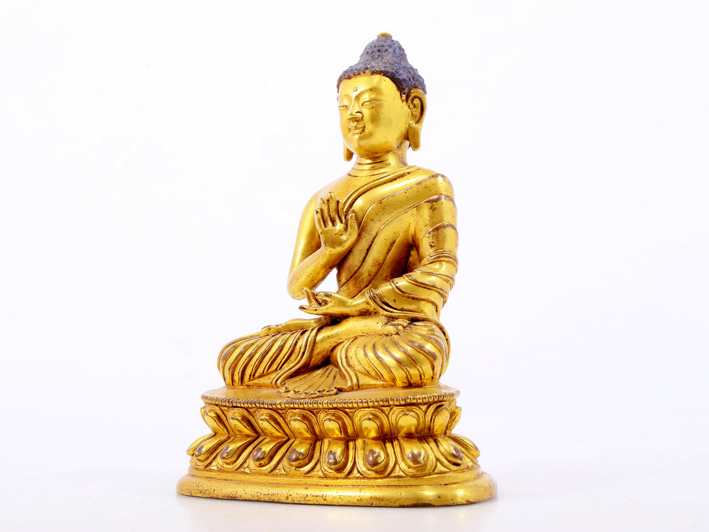 A serene gilt bronze statue of Gautama Buddha