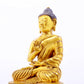 A serene gilt bronze statue of Gautama Buddha