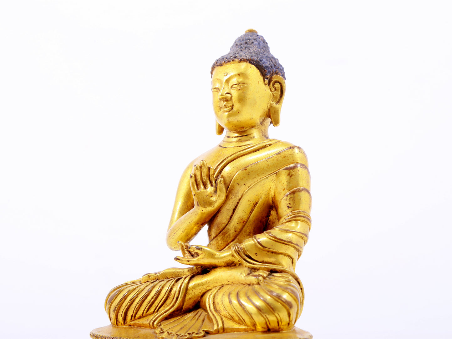 A serene gilt bronze statue of Gautama Buddha