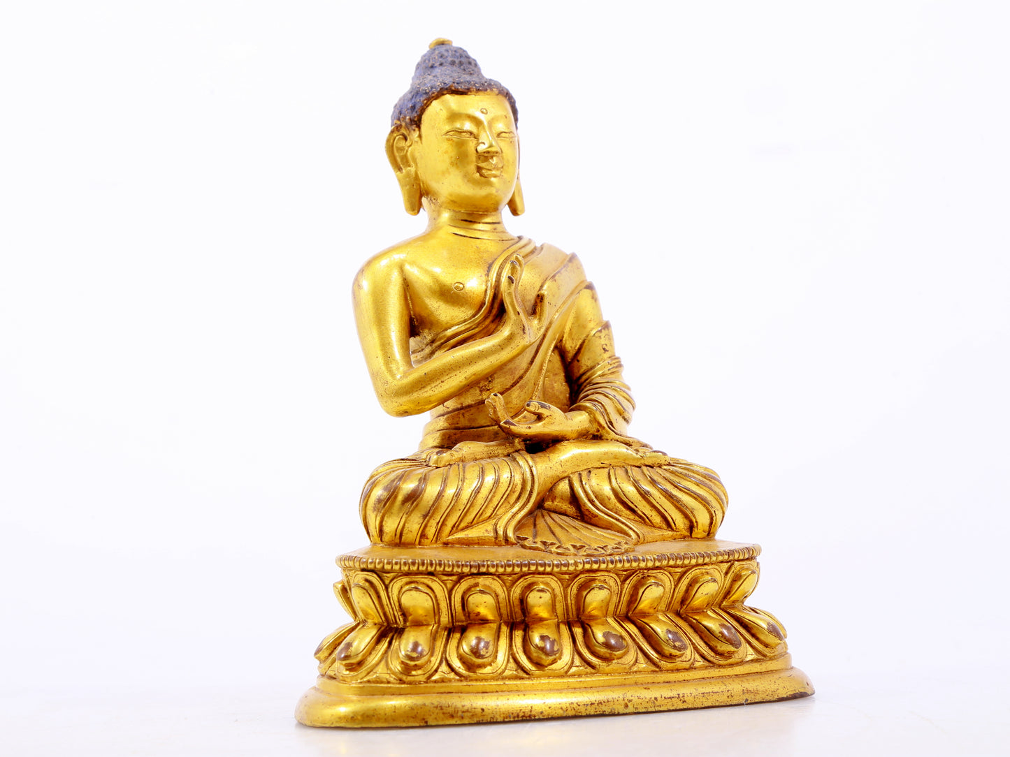 A serene gilt bronze statue of Gautama Buddha