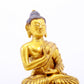 A serene gilt bronze statue of Gautama Buddha