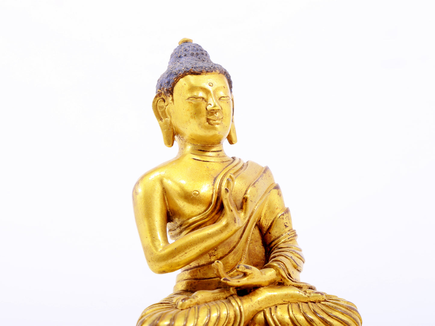 A serene gilt bronze statue of Gautama Buddha