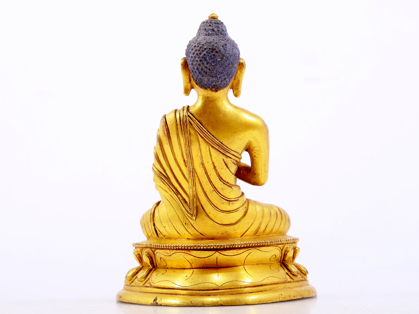 A serene gilt bronze statue of Gautama Buddha