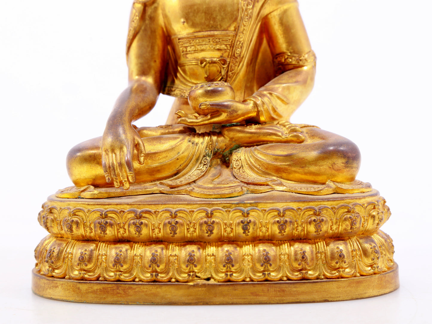 A serene gilt bronze statue of Gautama Buddha