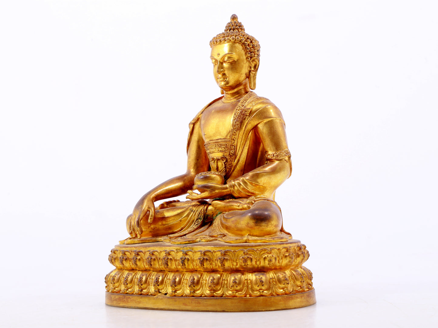 A serene gilt bronze statue of Gautama Buddha