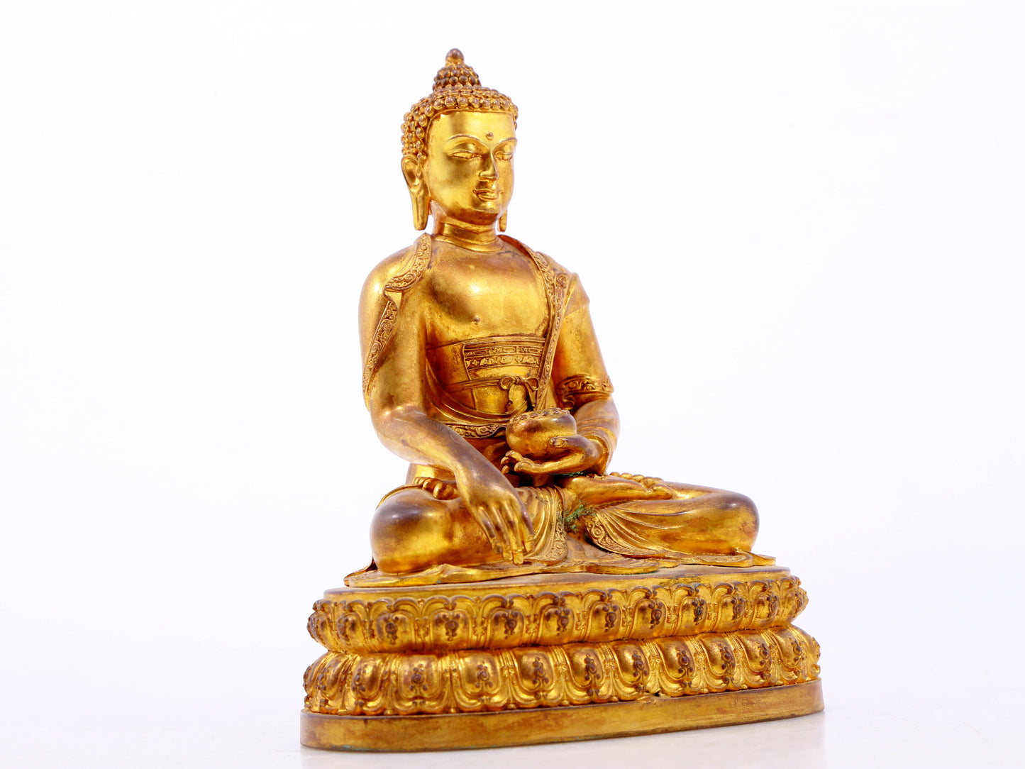 A serene gilt bronze statue of Gautama Buddha