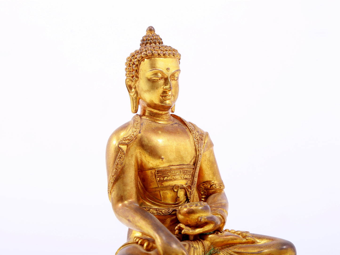 A serene gilt bronze statue of Gautama Buddha